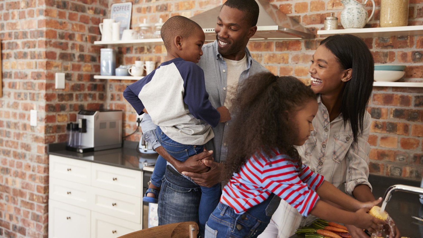 family stands near sink in kitchen