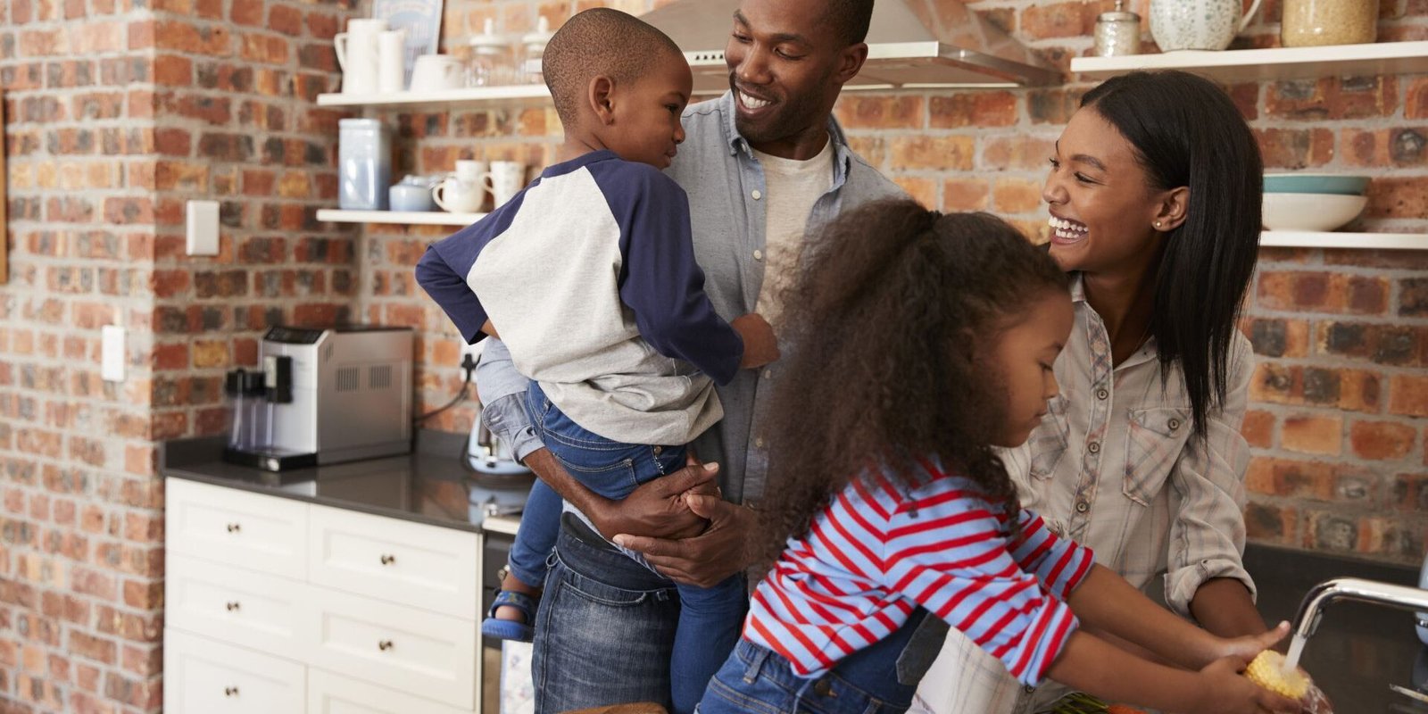 family stands near sink in kitchen